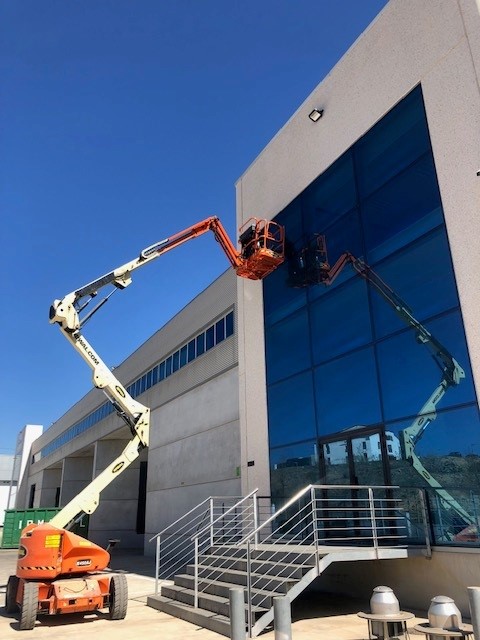 Limpieza de cristales en altura Sabadell - plataforma elevadora en fachada acristalada de edificio