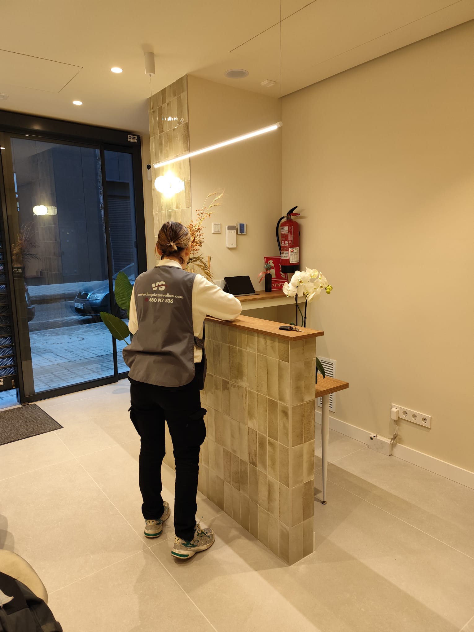 Limpieza de comunidades Sabadell - técnico VS limpiando portal moderno con recepción